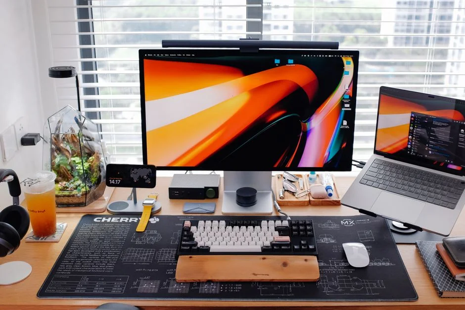 A modern workspace featuring dual computer monitors displaying web design projects, emphasizing technology and productivity.